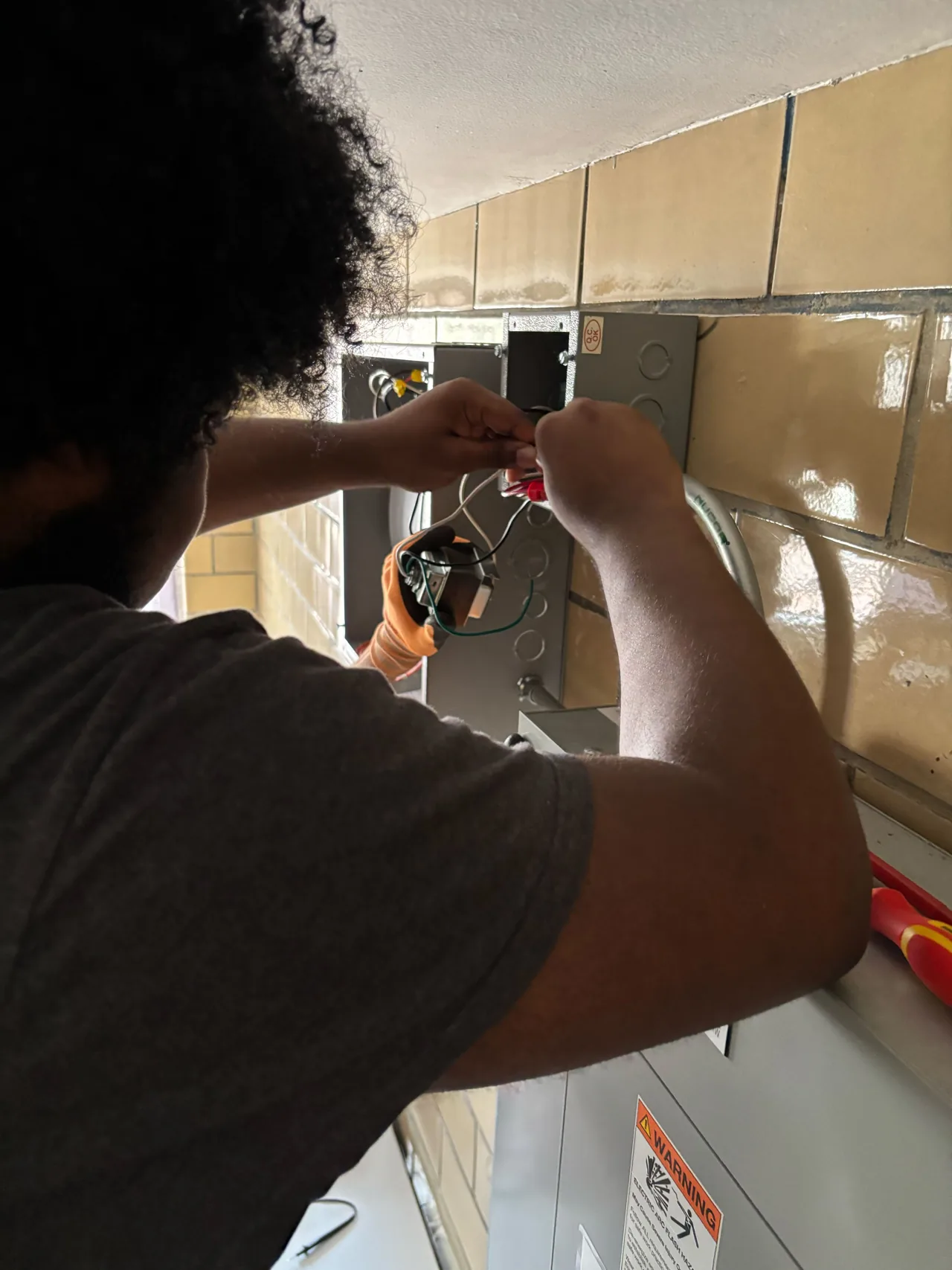 Trainees inspecting building equipment with an infrared thermometer.