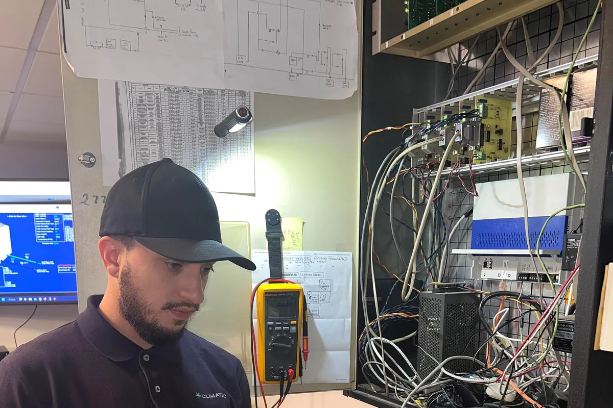 A trainee wiring a building control panel.